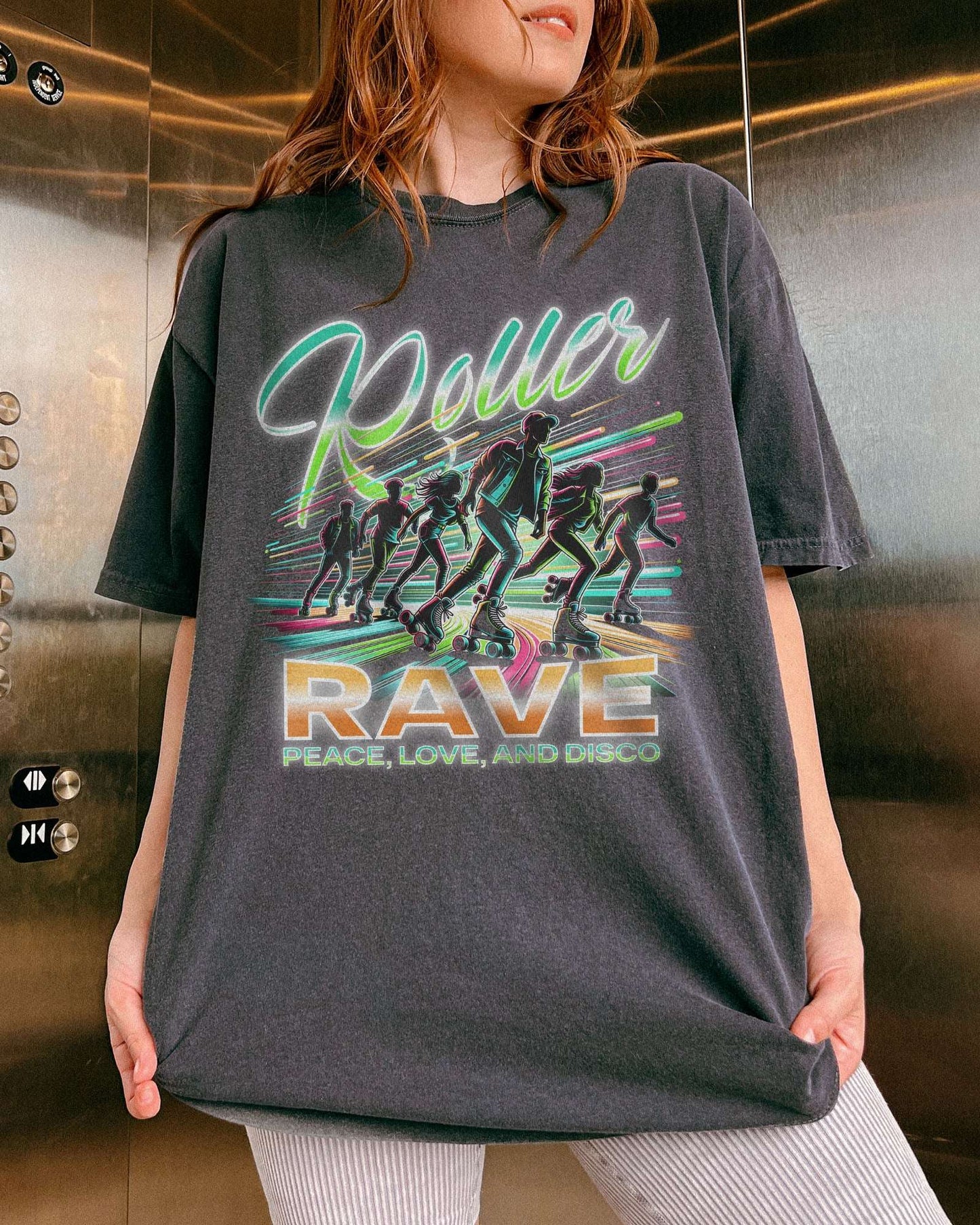 Woman wearing a pepper-colored 'Roller Rave – Peace, Love, and Disco' shirt with a retro 80’s graphic of a roller skater group vibing at a roller skating rink.