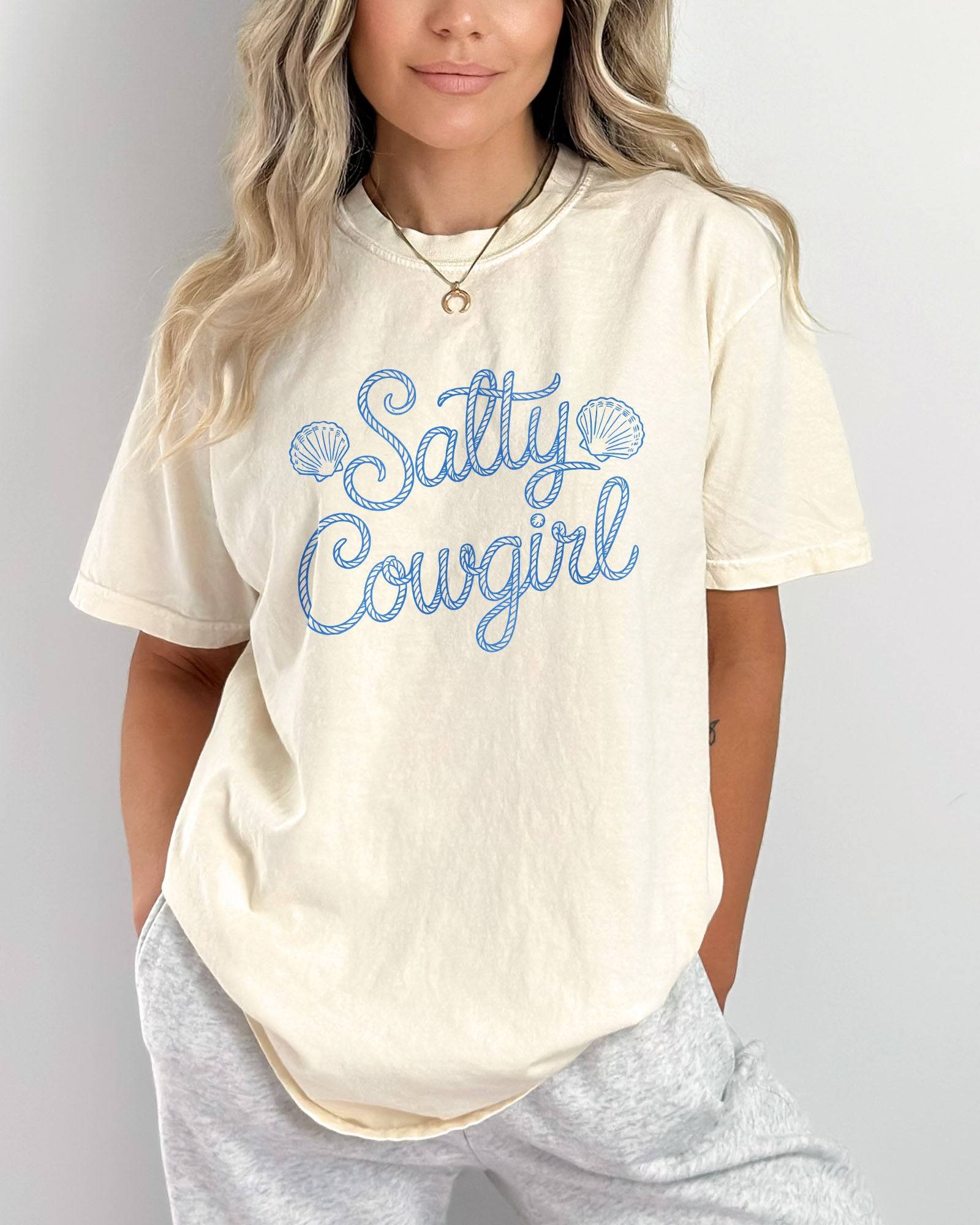 Woman wearing an ivory 'Salty Cowgirl' shirt.
