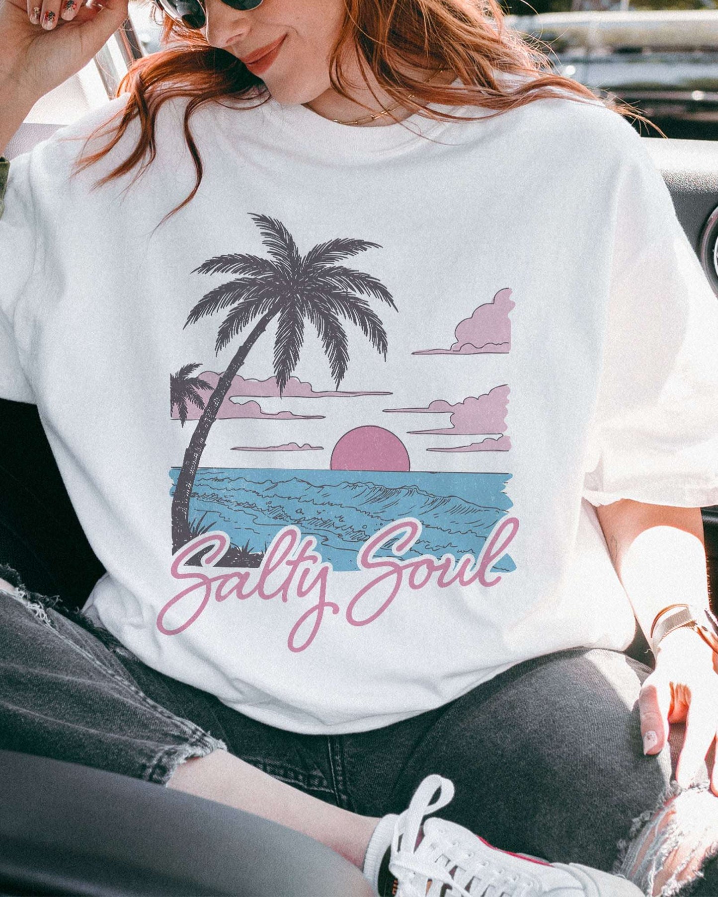 Close-up of model wearing white color shirt with 'Salty Soul' funny retro beach graphic design