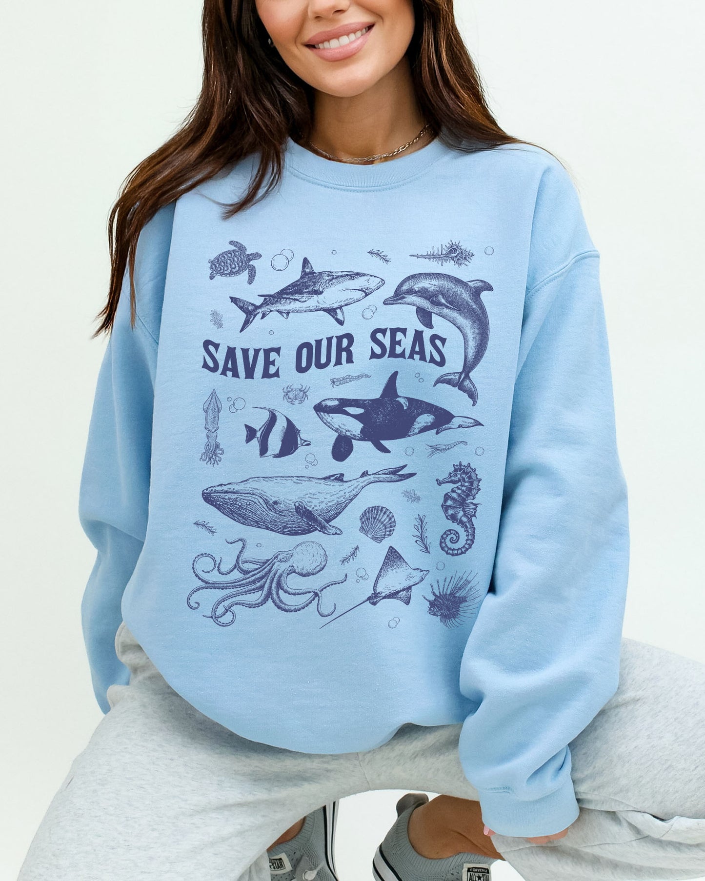 Model wearing light blue color sweatshirt with 'Save Our Seas' graphic design