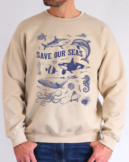 Model wearing sand color sweatshirt with 'Save Our Seas' graphic design