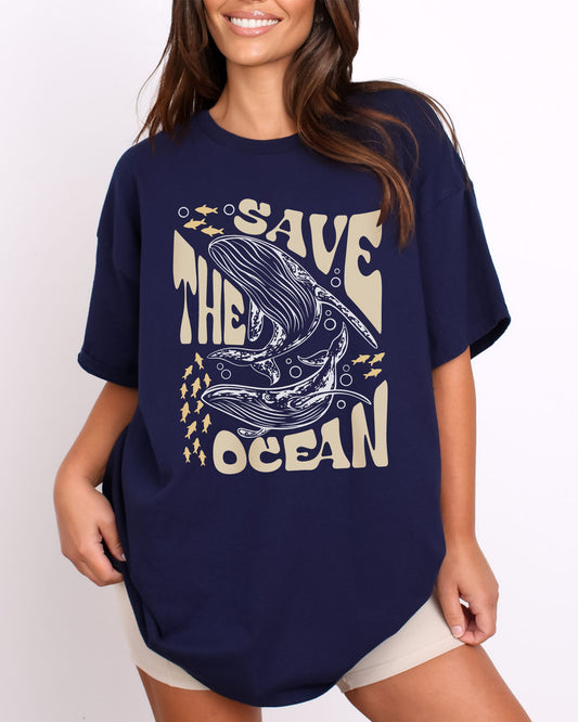 Woman wearing a navy blue 'Save The Ocean' t-shirt featuring a retro whales and ocean life graphic.
