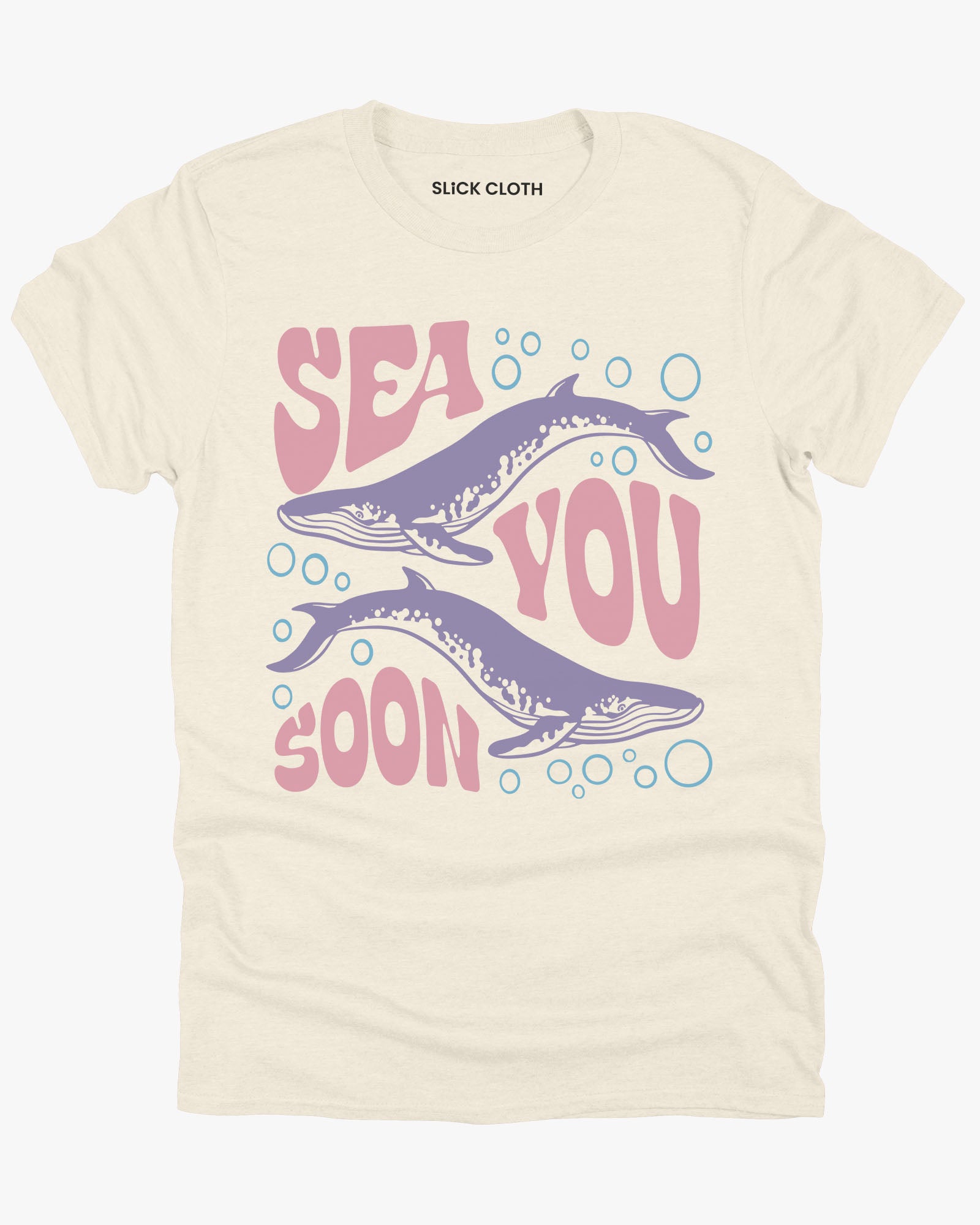 Flat lay of a natural-colored 'Sea You Soon' t-shirt with a retro whales and sea life graphic.