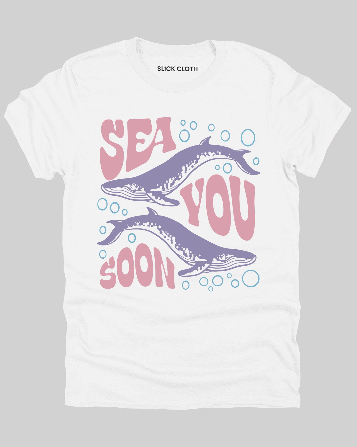 Flat lay of a white 'Sea You Soon' t-shirt featuring a retro whales and sea life graphic.