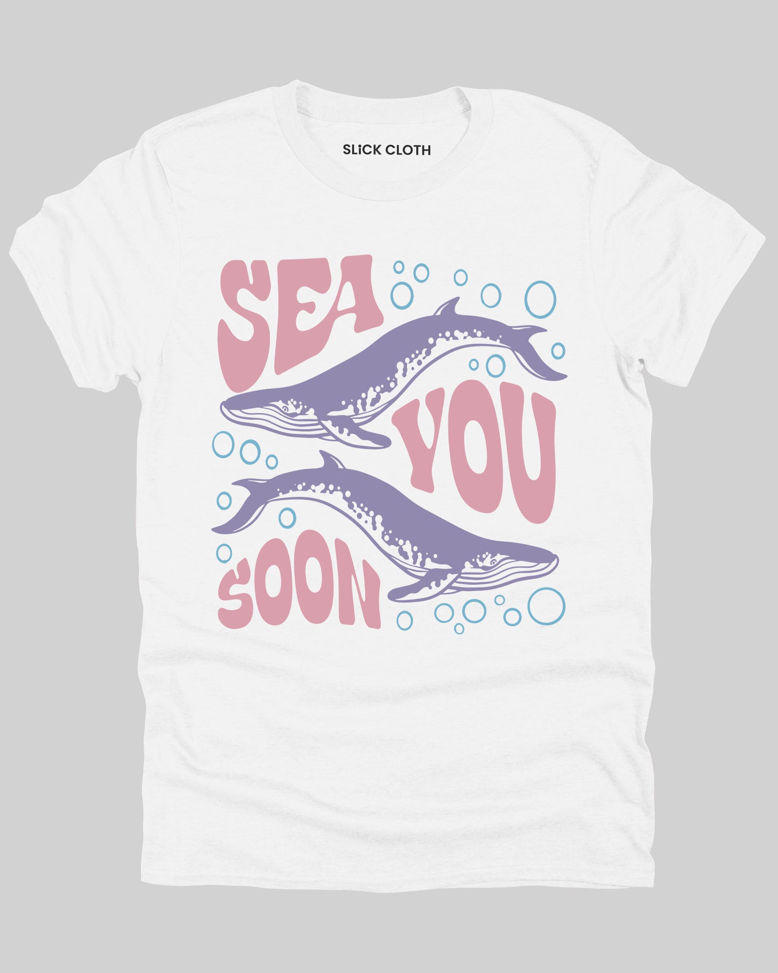 Flat lay of a white 'Sea You Soon' t-shirt featuring a retro whales and sea life graphic.
