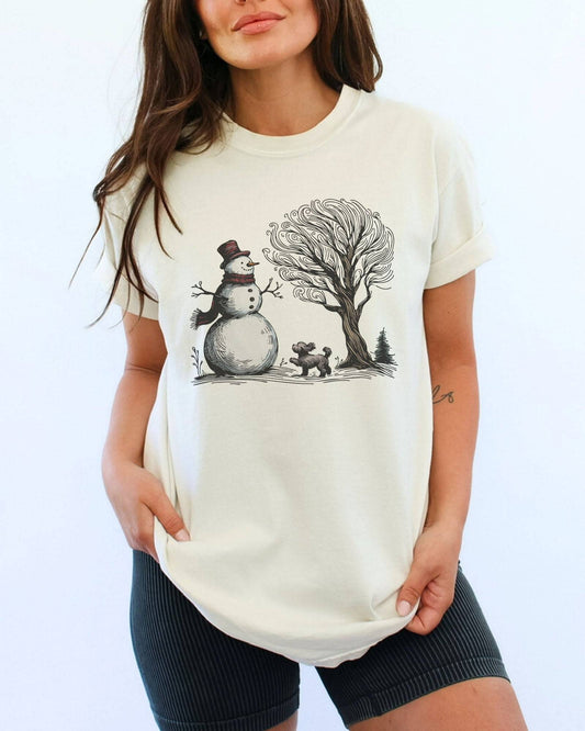 Model wearing ivory color shirt with snowman and og winter landscape graphic design