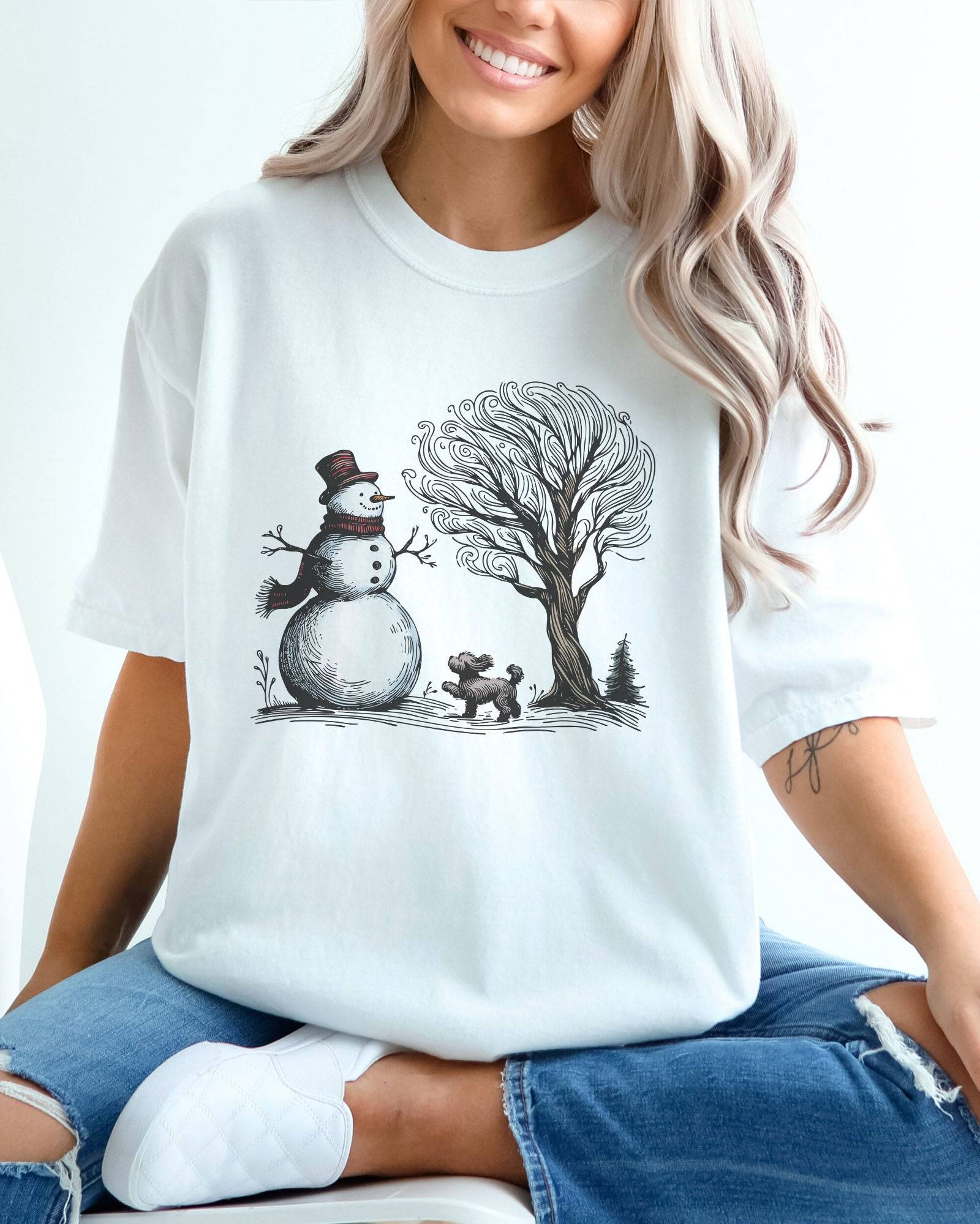 Model wearing white color shirt with snowman and og winter landscape graphic design