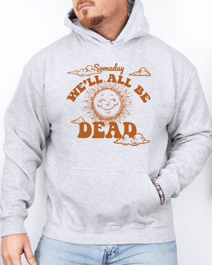 Man wearing an ash gray hoodie featuring a funny retro-style laughing sun graphic and the quote 'Someday We'll All Be Dead'.