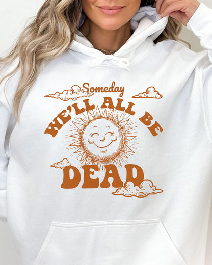 Close-up of a woman wearing a white hoodie featuring a funny retro-style laughing sun graphic and the quote 'Someday We'll All Be Dead'.