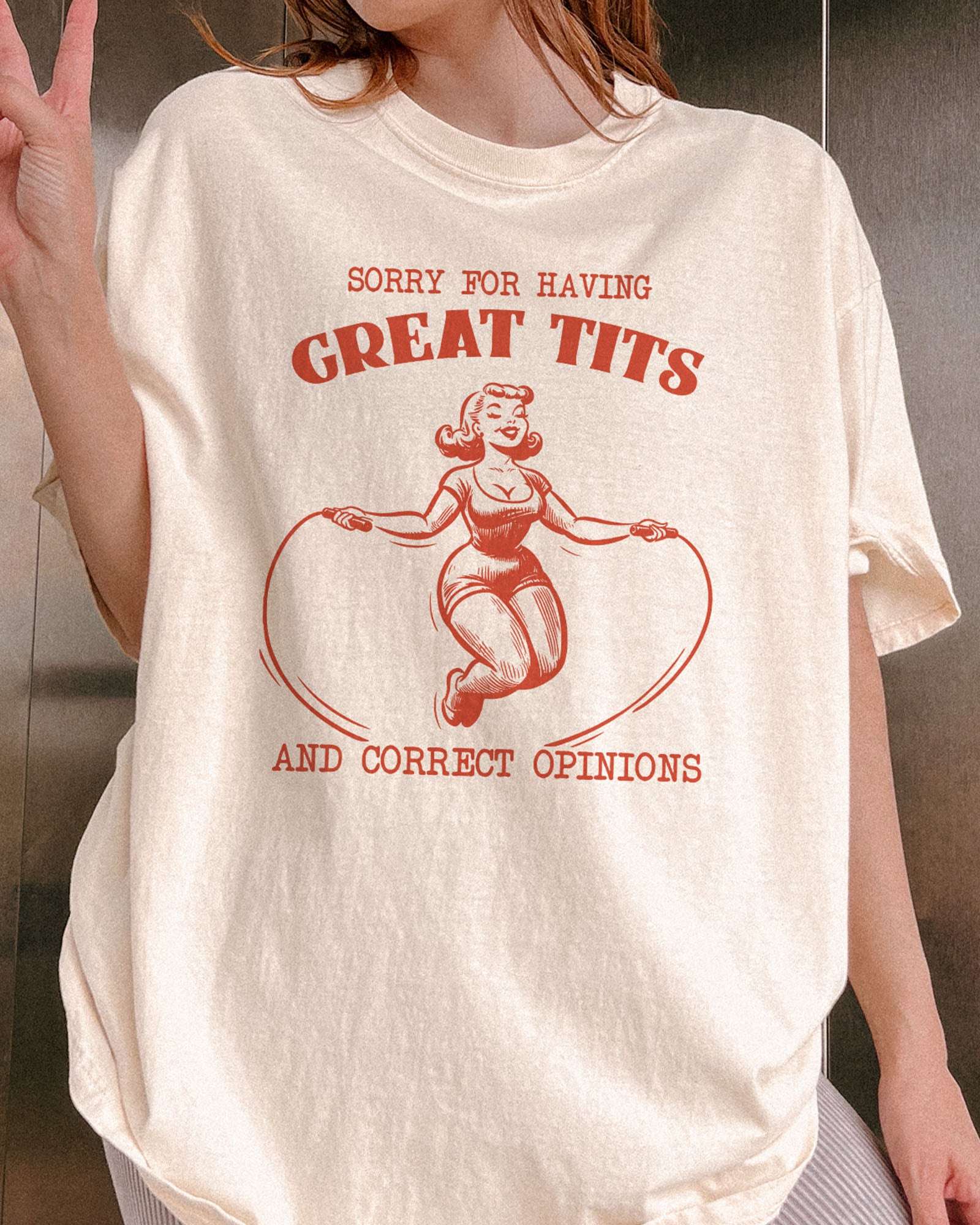 Close-up of "Sorry For Having Great Tits And Correct Opinions" shirt and an outline graphic of a curvy woman jumping rope.