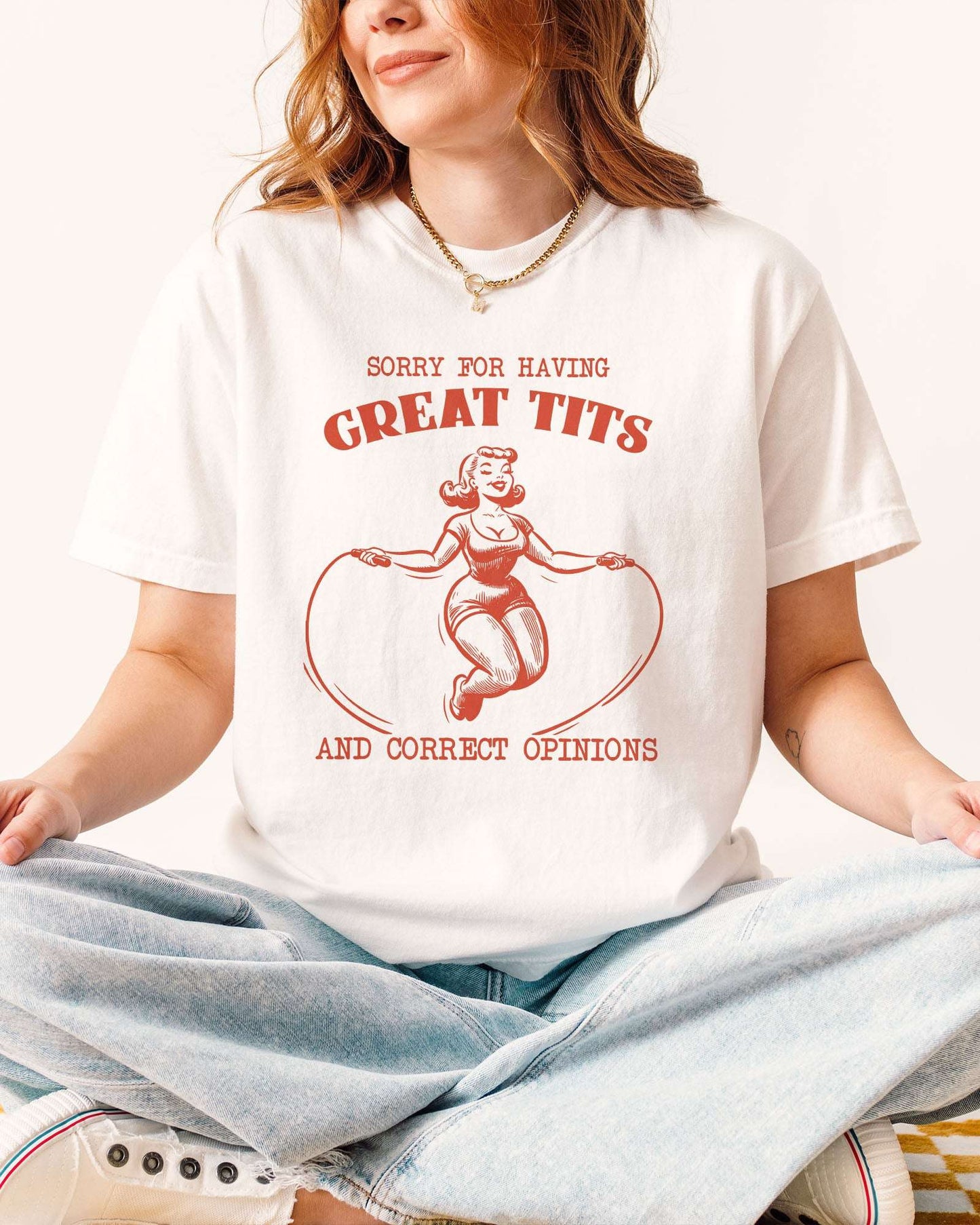 Woman wearing funny white t-shirt with quote "Sorry For Having Great Tits And Correct Opinions" and an outline graphic of a curvy woman jumping rope.