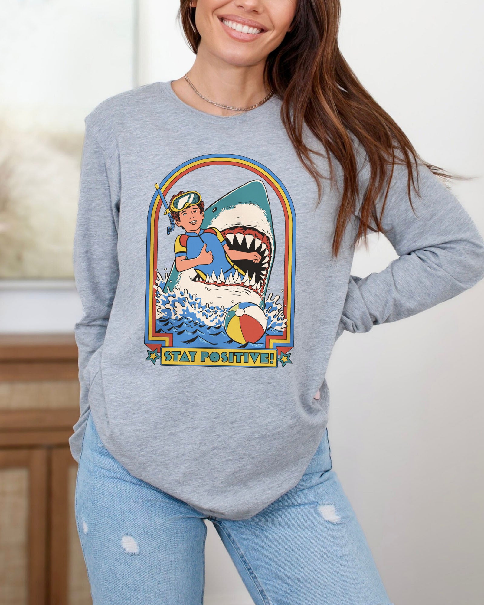 Model wearing sport gray color long sleeve tee with 'Stay Positive Shark' graphic design