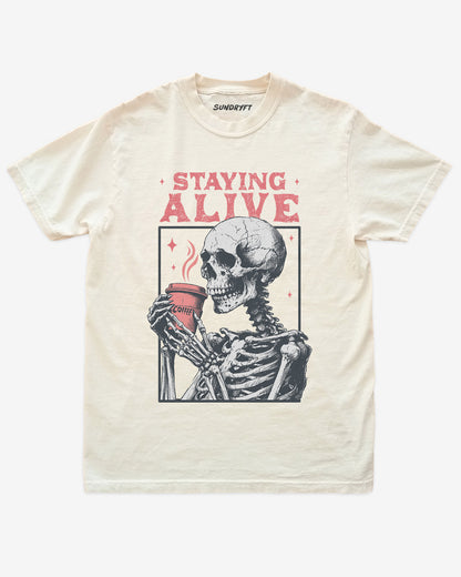 Staying Alive shirt in ivory with skeleton drinking coffee graphic