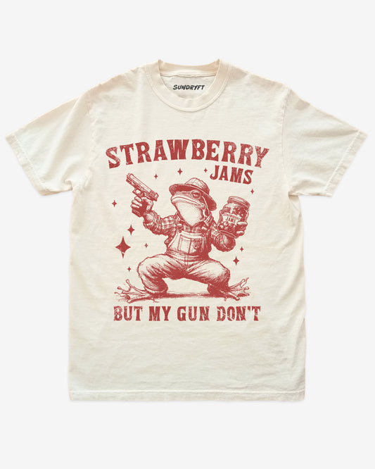 Strawberry Jams But My Gun Don't shirt in ivory with funny frog holding a jar of strawberry jam and a gun graphic