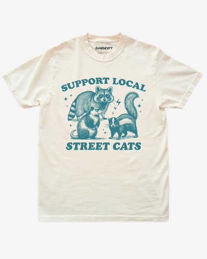Support Local Street Cats shirt in ivory with funny graphic of raccoon, opossum, and skunk wearing sunglasses