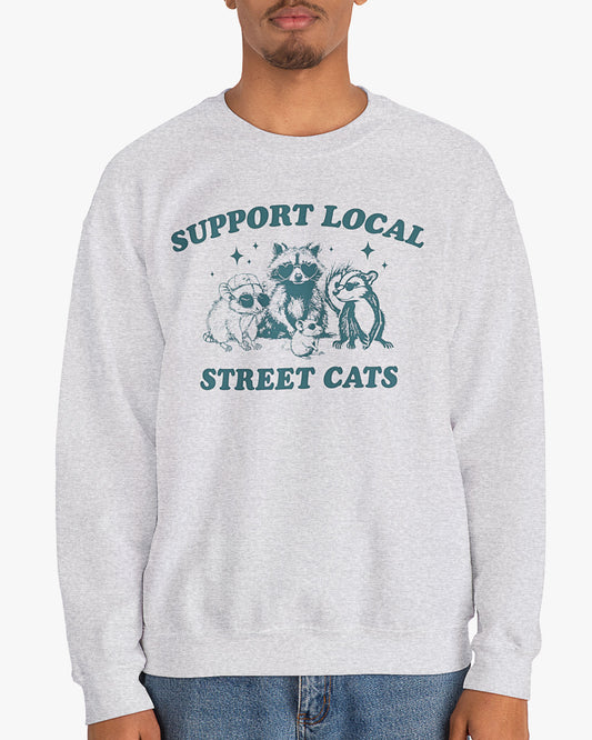 Man wearing ash gray 'Support Local Street Cats' sweatshirt with funny retro raccoon and opossum graphic
