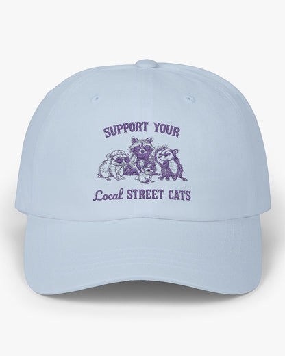 Light blue dad cap with the quote 'Support Your Local Street Cats' and a funny retro raccoon and opossum graphic.