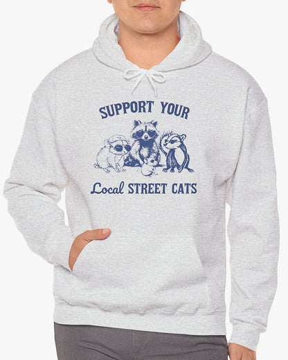 Man wearing ash gray 'Support Your Local Street Cats' hoodie with funny retro raccoon and opossum gang graphic