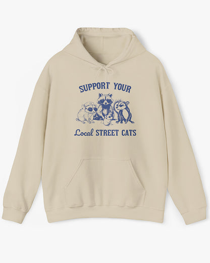 Flat lay sand beige 'Support Your Local Street Cats' hoodie with funny retro raccoon and opossum gang graphic