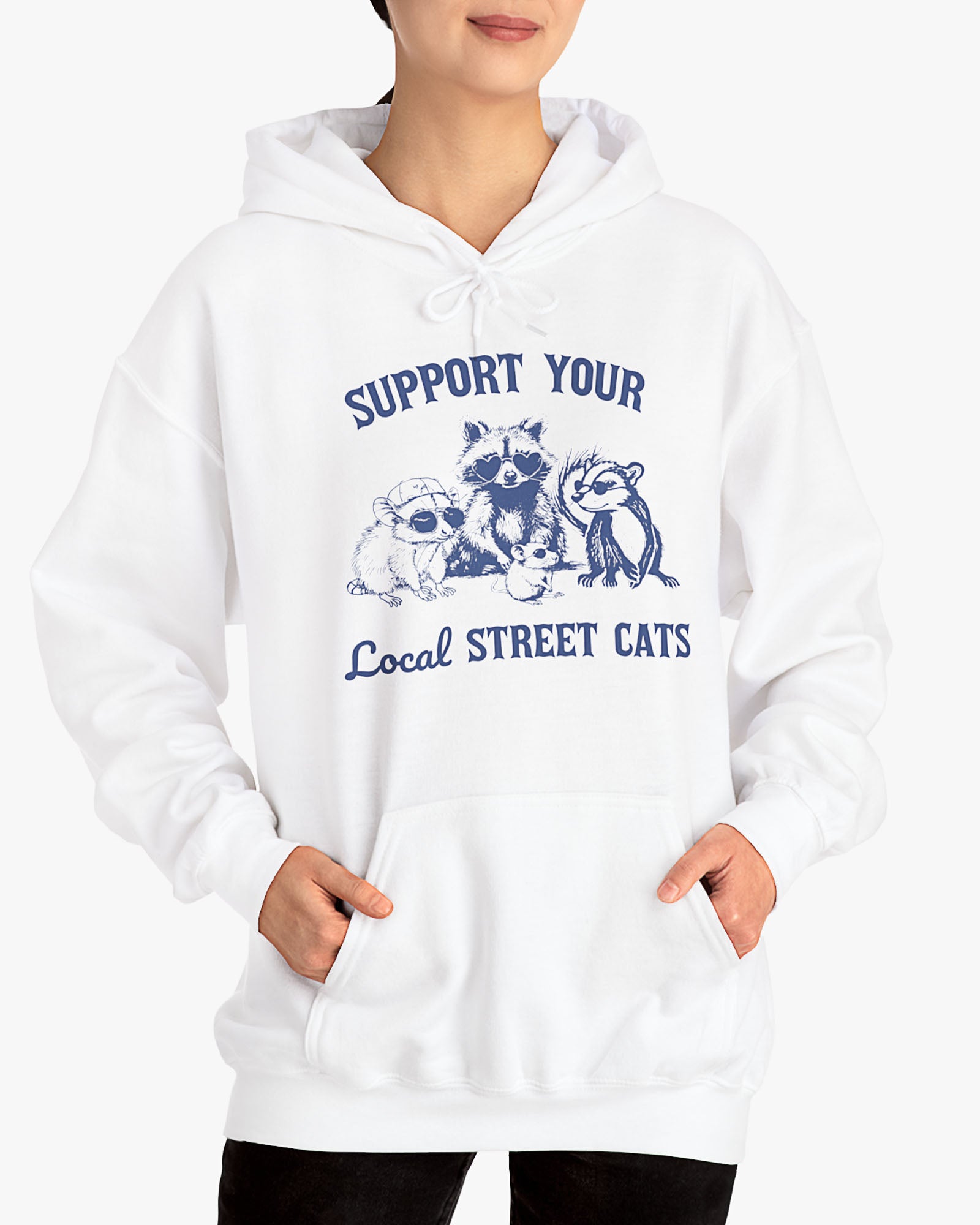 Woman wearing white 'Support Your Local Street Cats' hoodie with funny retro raccoon and opossum gang graphic