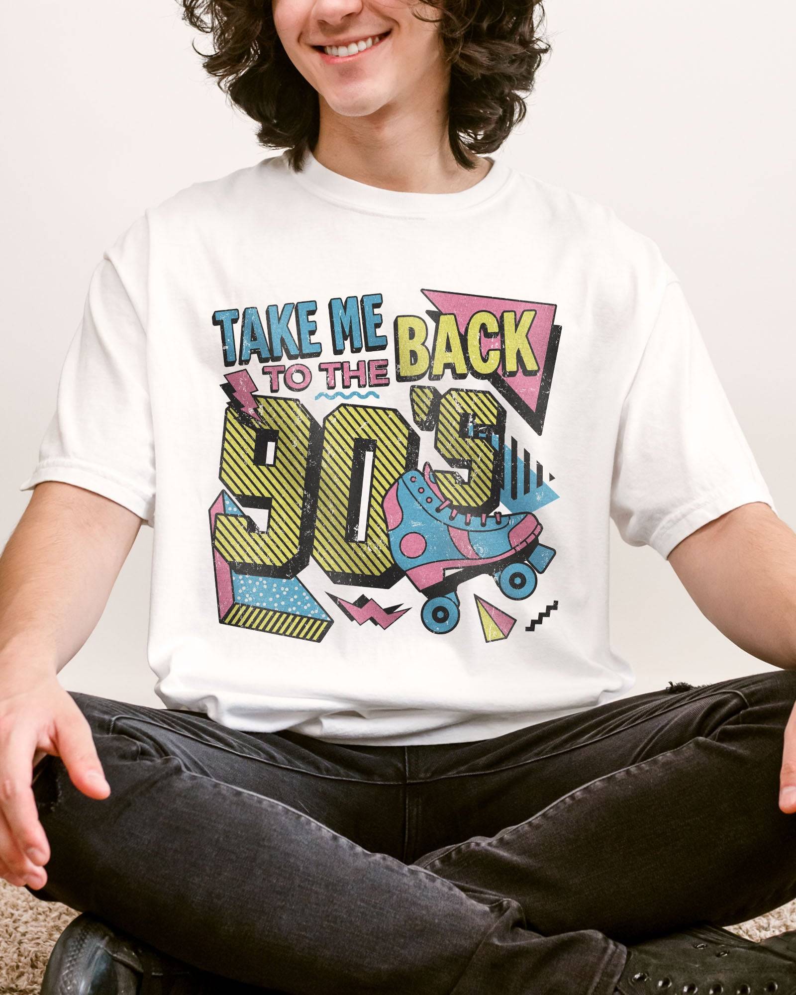 Man wearing a white "Take Me Back To The 90's" retro graphic shirt.