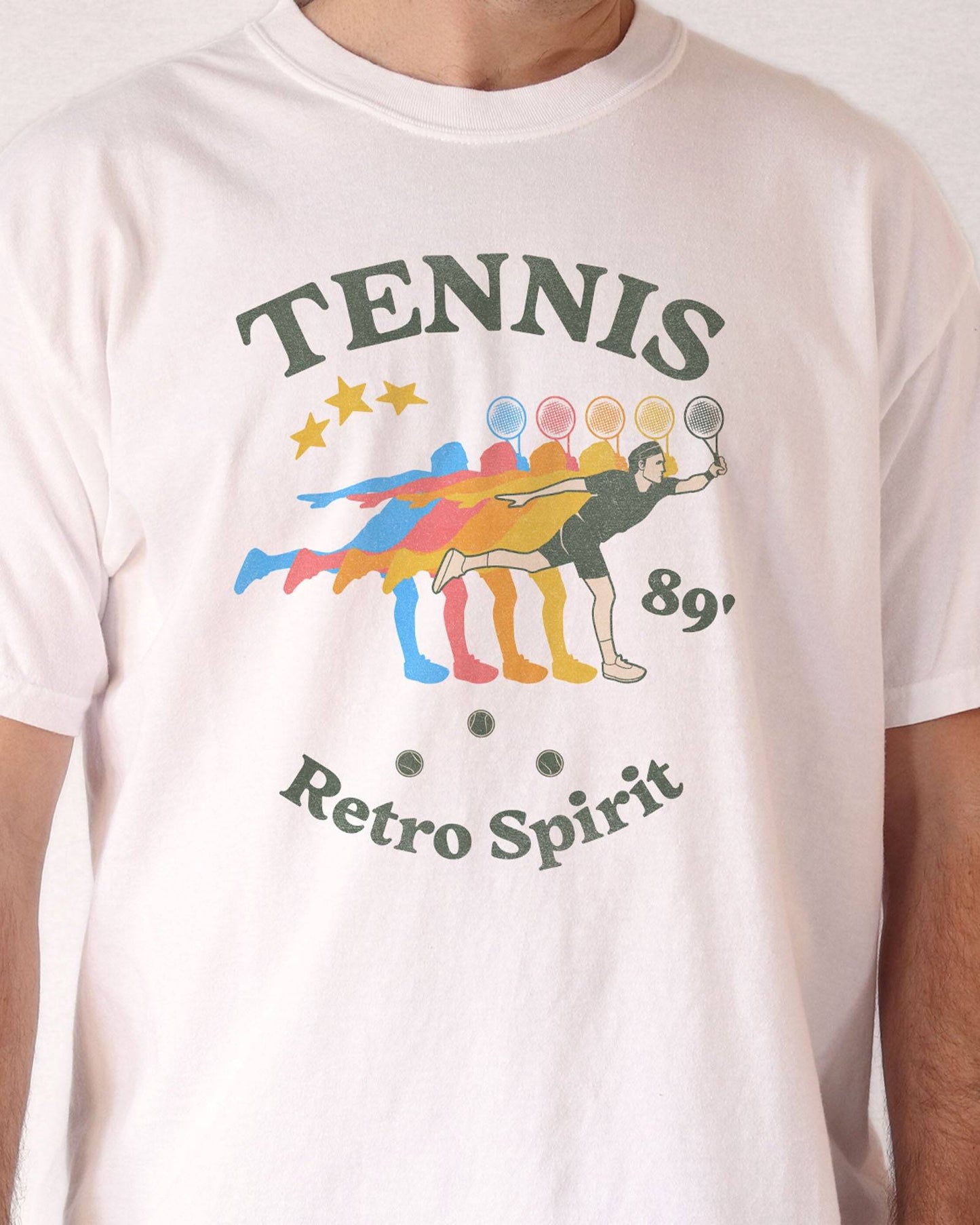 Close-up of man wearing "Tennis 89' Retro Spirit" shirt in white color with a vintage tennis player graphic.