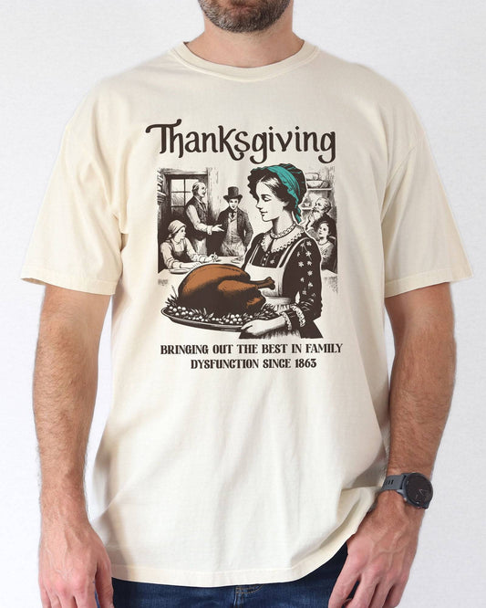Model wearing ivory color shirt with 'Thanksgiving - Bringing Out The Best In Family Dysfunction Since 1863' graphic design