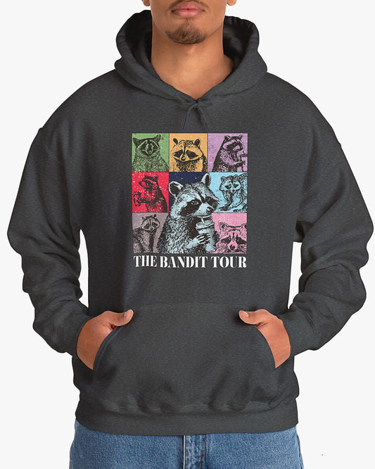 Man wearing dark heather 'The Bandit Tour' hoodie with funny retro raccoon collage 