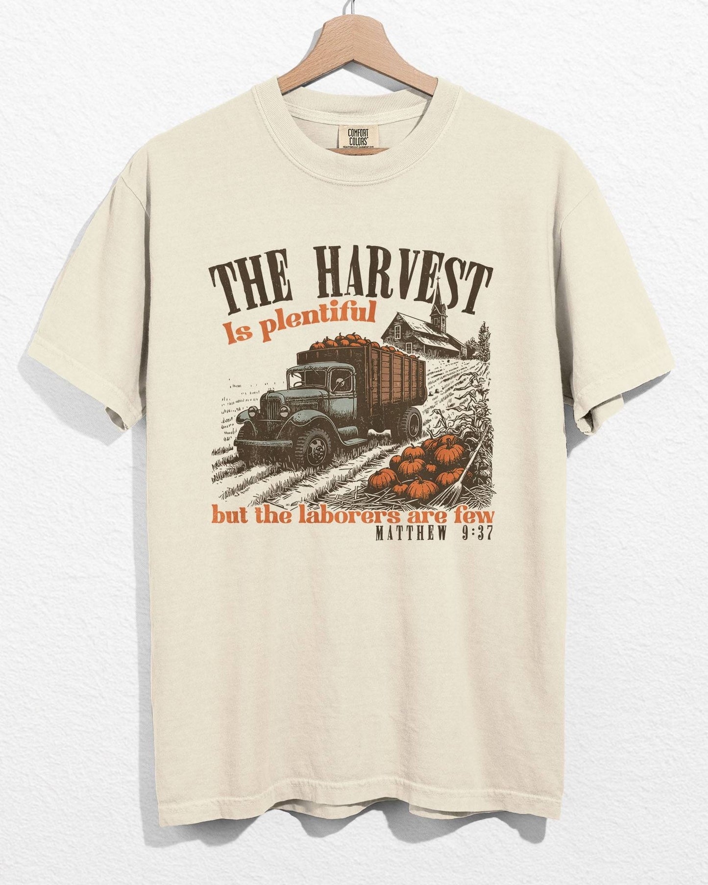 Ivory color hanging shirt with 'The Harvest Is Plentiful, But The Laborers Are Few - Matthew 9:37' Thanksgiving graphic design