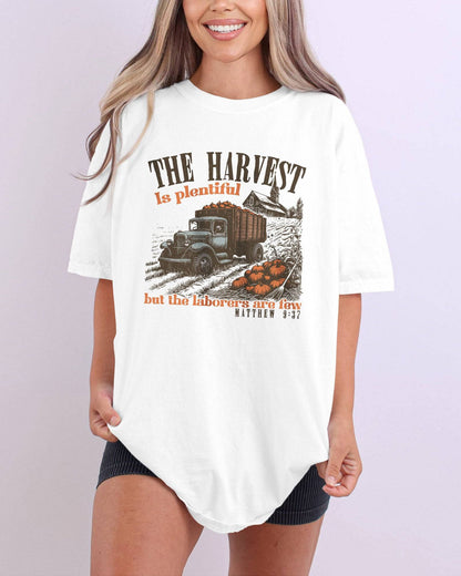 Model wearing ivory color shirt with 'The Harvest Is Plentiful, But The Laborers Are Few - Matthew 9:37' Thanksgiving graphic design