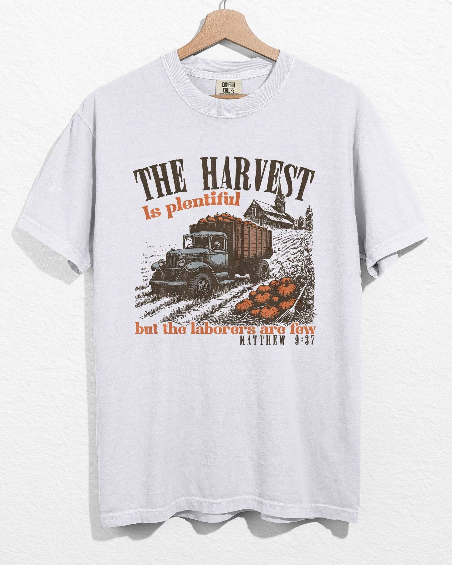 White color hanging shirt with 'The Harvest Is Plentiful, But The Laborers Are Few - Matthew 9:37' Thanksgiving graphic design