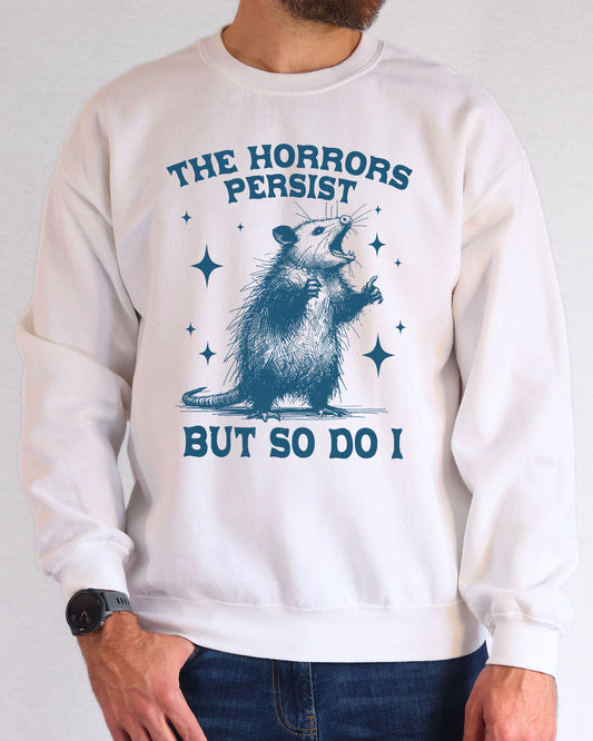 Model wearing white color sweatshirt with 'The Horrors Persist, But So Do I' graphic design