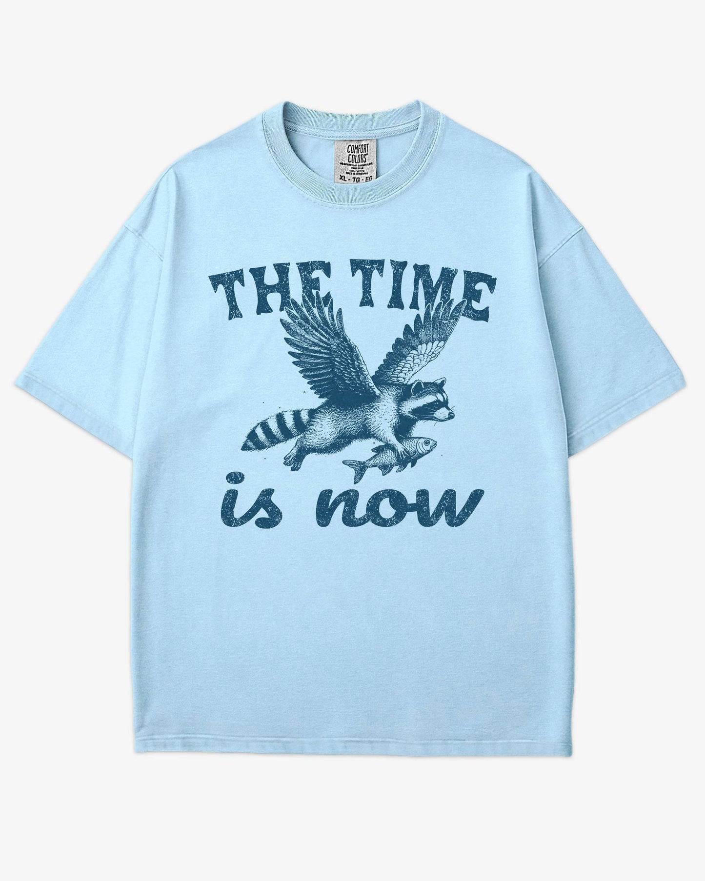 The Time Is Now Shirt flat lay chambray unisex retro tee with funny flying raccoon graphic