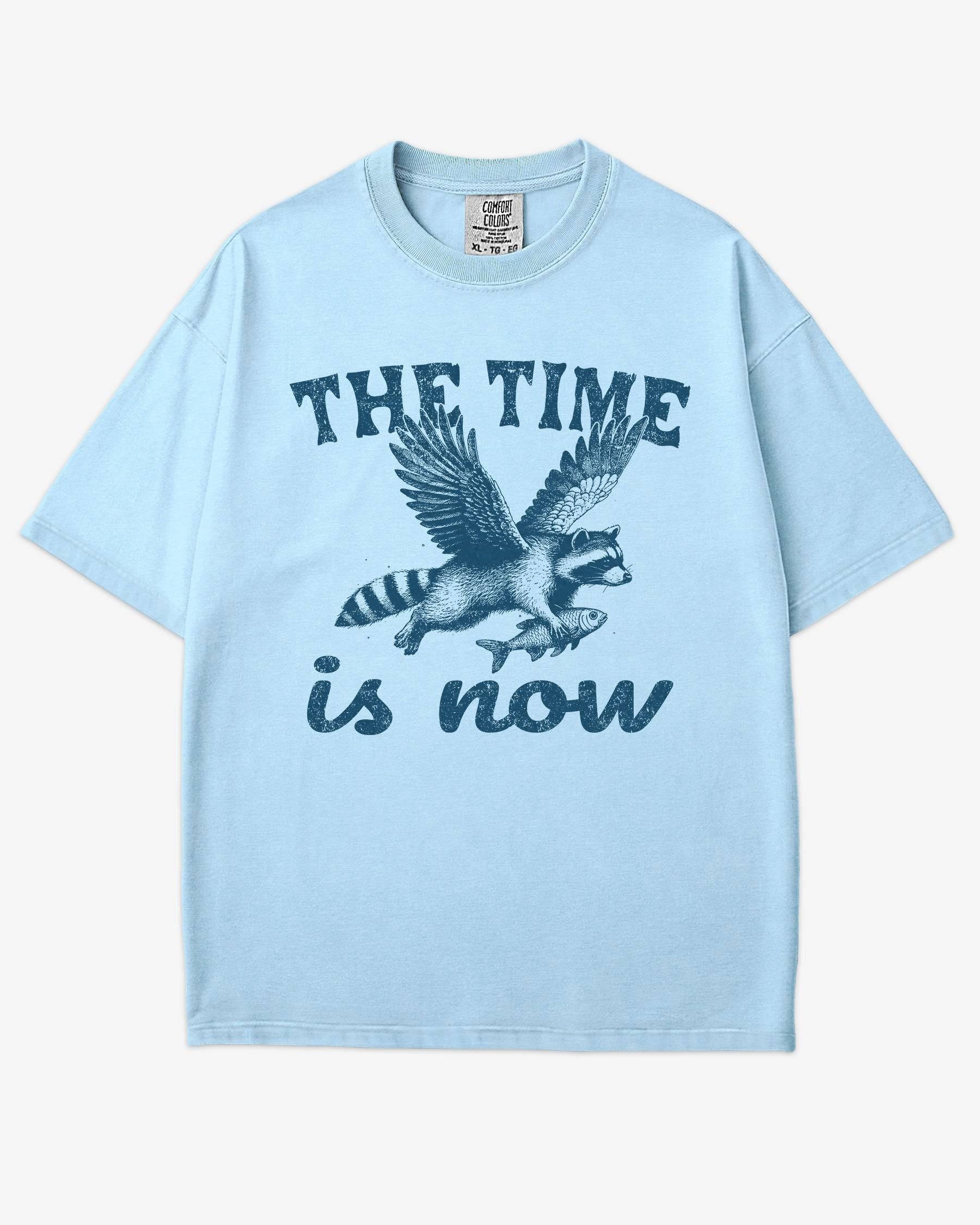 The Time Is Now Shirt flat lay chambray unisex retro tee with funny flying raccoon graphic
