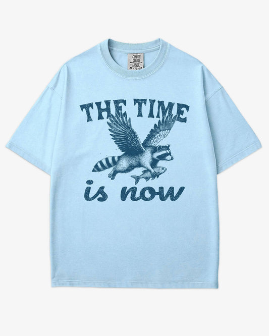 The Time Is Now Shirt flat lay chambray unisex retro tee with funny flying raccoon graphic
