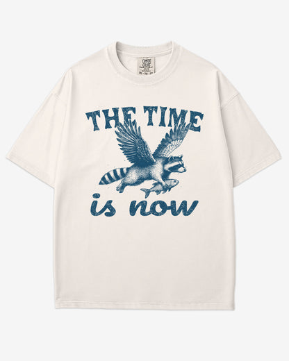The Time Is Now Shirt flat lay unisex ivory retro tee with funny flying raccoon graphic