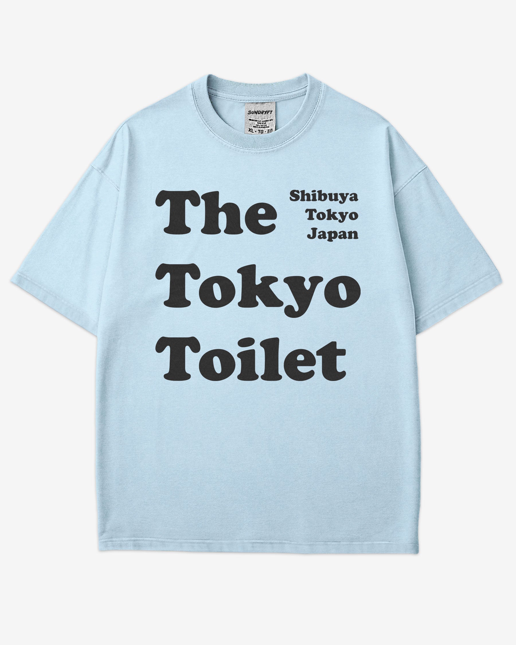Flat lay chambray Tokyo Toilet shirt with a retro graphic inspired by Shibuya’s public restrooms.