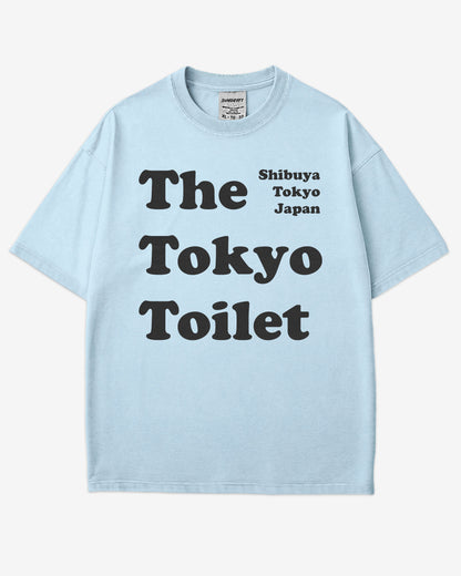 Flat lay chambray Tokyo Toilet shirt with a retro graphic inspired by Shibuya’s public restrooms.