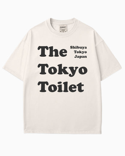 Flat lay ivory Tokyo Toilet shirt with a retro graphic inspired by Shibuya’s public restrooms.