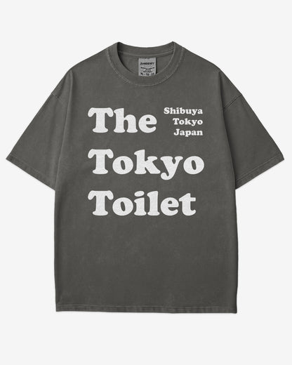 Flat lay pepper Tokyo Toilet shirt with a retro graphic inspired by Shibuya’s public restrooms.