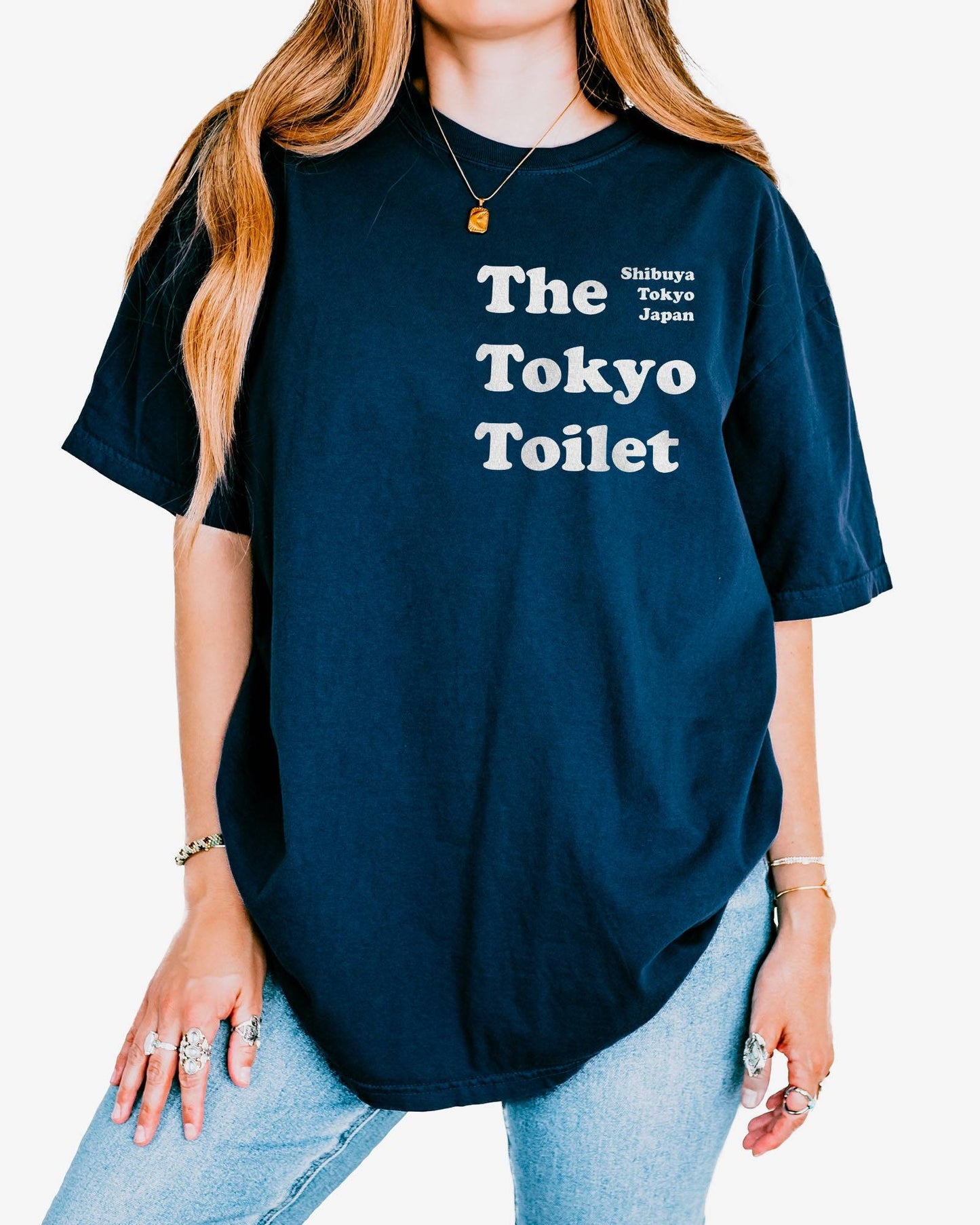 Woman wearing a true navy 'The Tokyo Toilet' shirt.