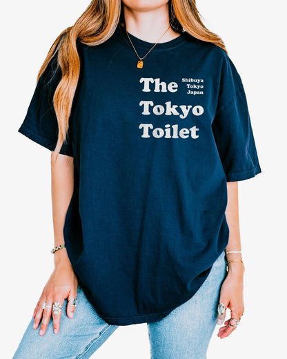 Woman wearing a true navy 'The Tokyo Toilet' shirt.