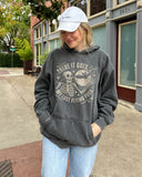 Woman wearing pepper 'There It Goes My Last Flying Fuck' hoodie with funny retro skeleton and bat Halloween graphic.