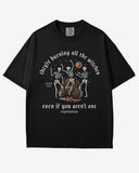 They’re Burning All The Witches Shirt – flat lay black tee with funny retro skeletons dancing in fire graphic