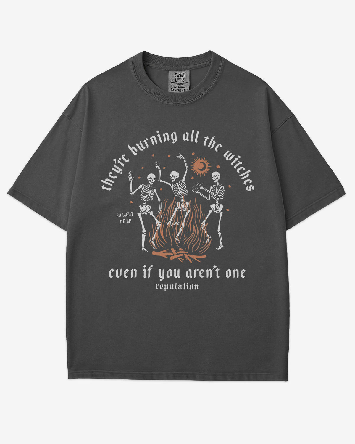 They’re Burning All The Witches Shirt – flat lay graphite tee with funny retro skeletons dancing in fire graphic