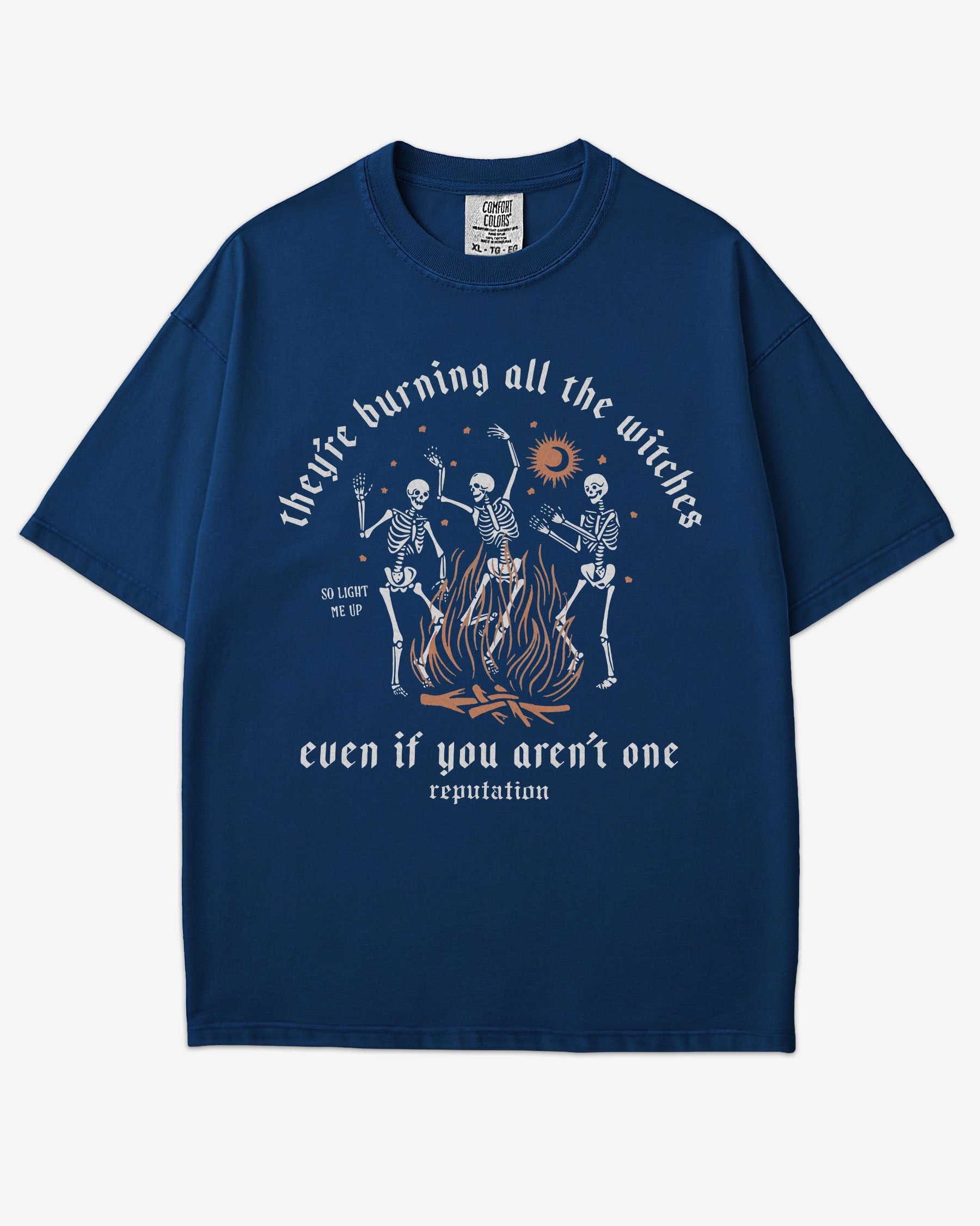 They’re Burning All The Witches Shirt – flat lay true navy tee with funny retro skeletons dancing in fire graphic