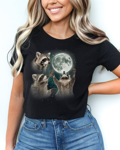 Black crop top with a retro graphic of three raccoons howling at the moon, worn by a woman.