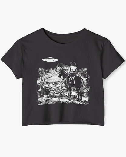 Flat-lay black crop top featuring a UFO and western desert scenery graphic.