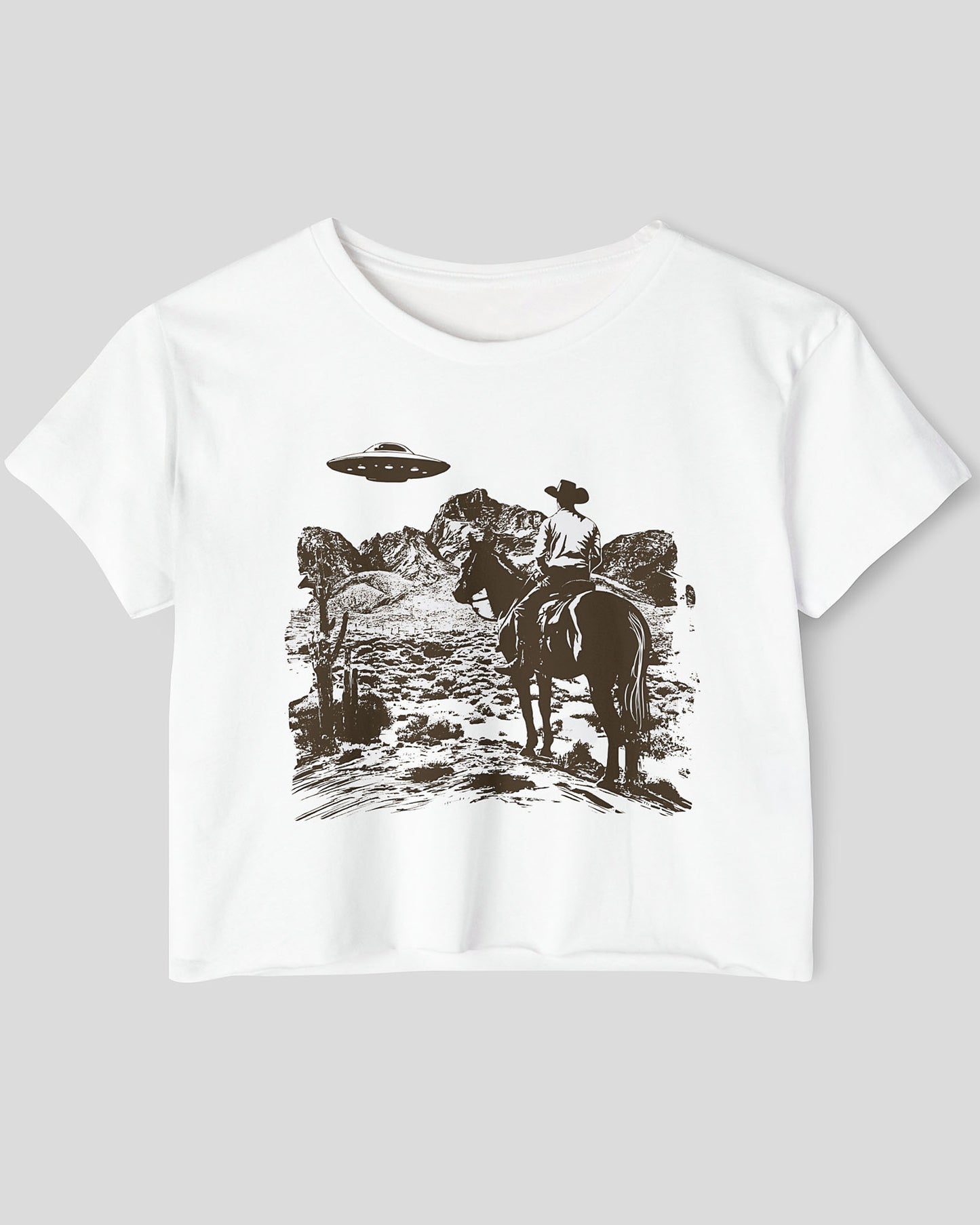 Flat-lay white crop top featuring a UFO and western desert scenery graphic.