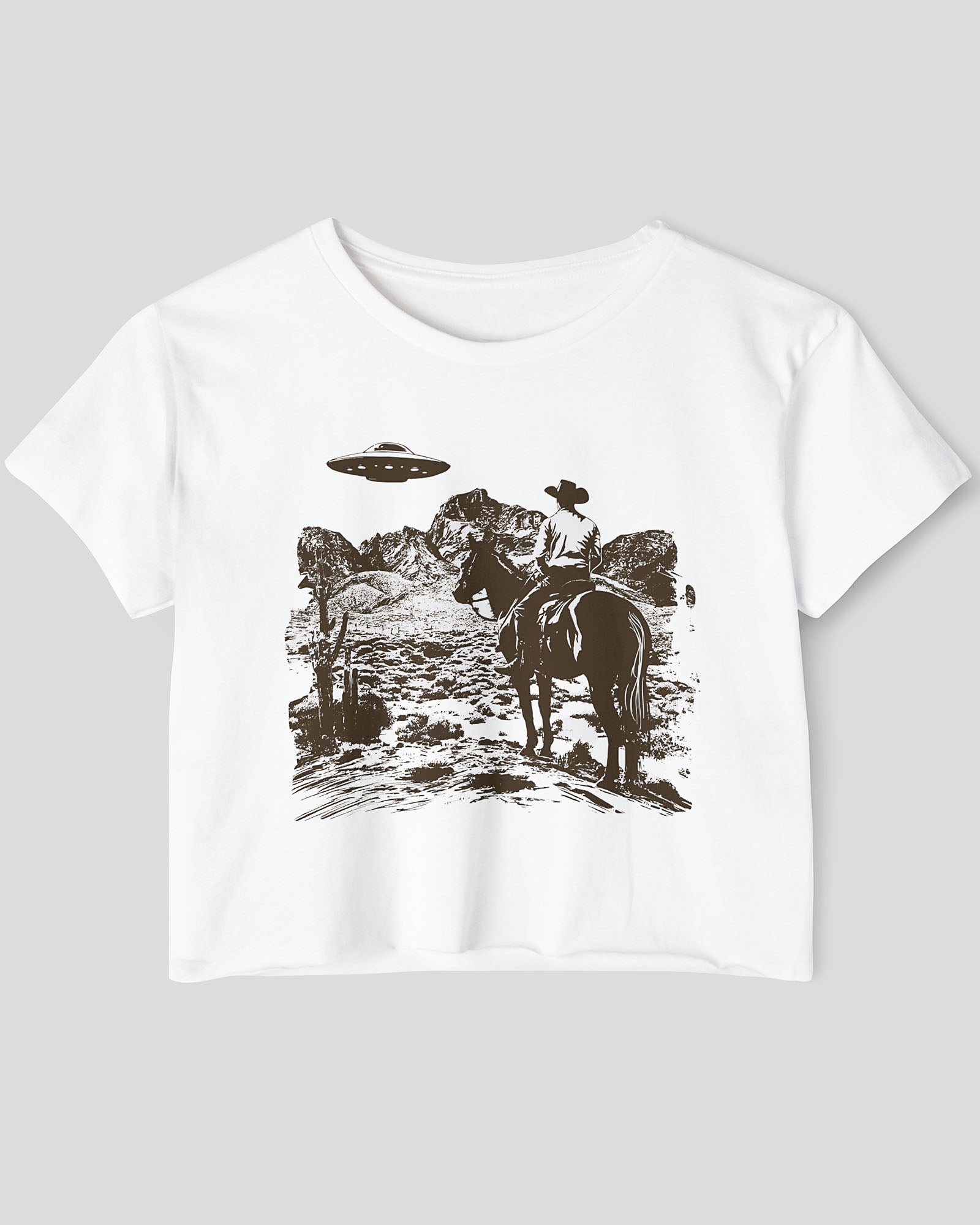 Flat-lay white crop top featuring a UFO and western desert scenery graphic.
